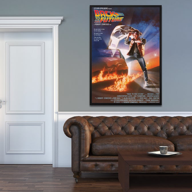 Movie poster in a wooden frame with shatterproof clear acrylic protection above a sofa